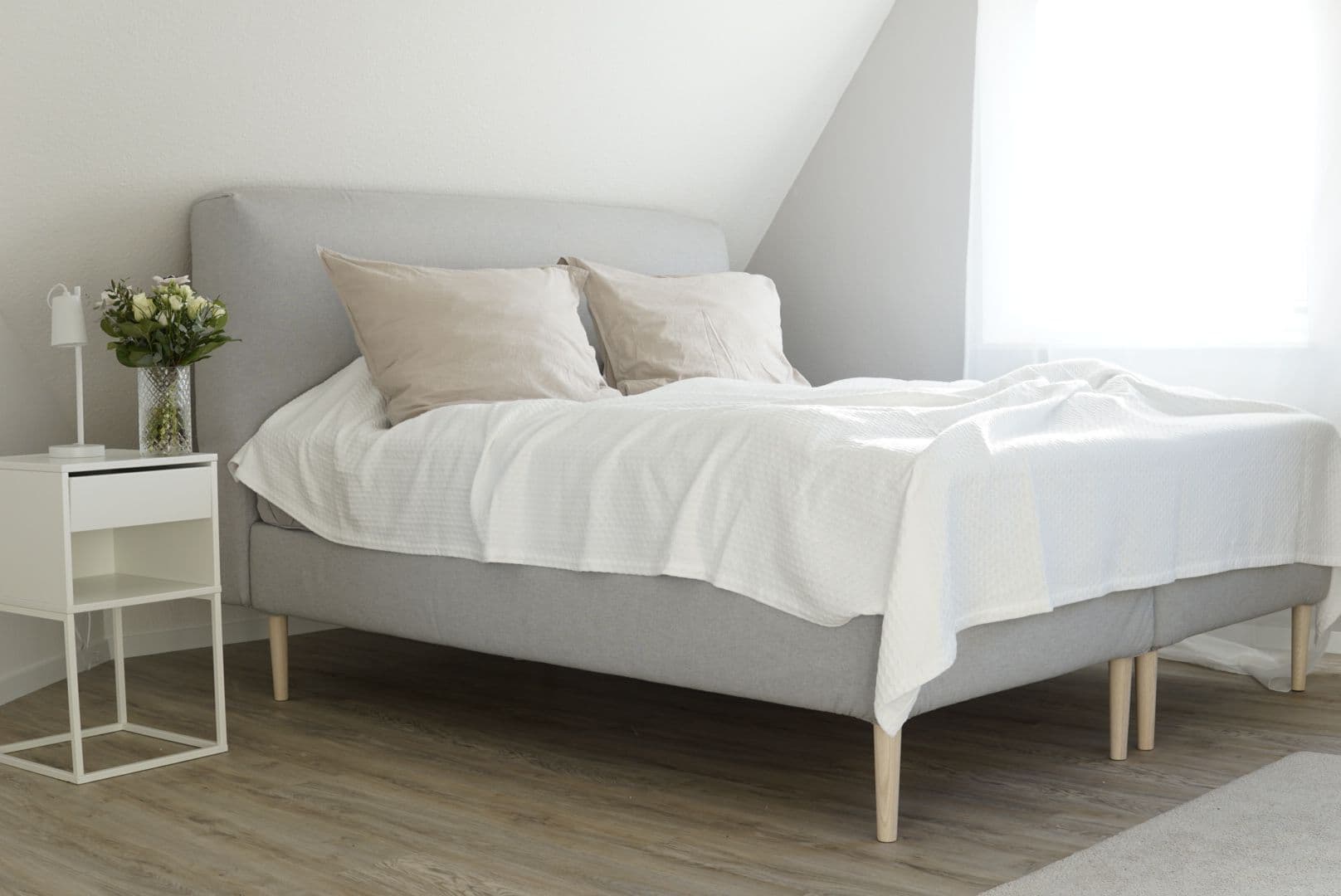 lit IKEA scandinave avec pieds en bois clair dans une chambre calme et minimaliste