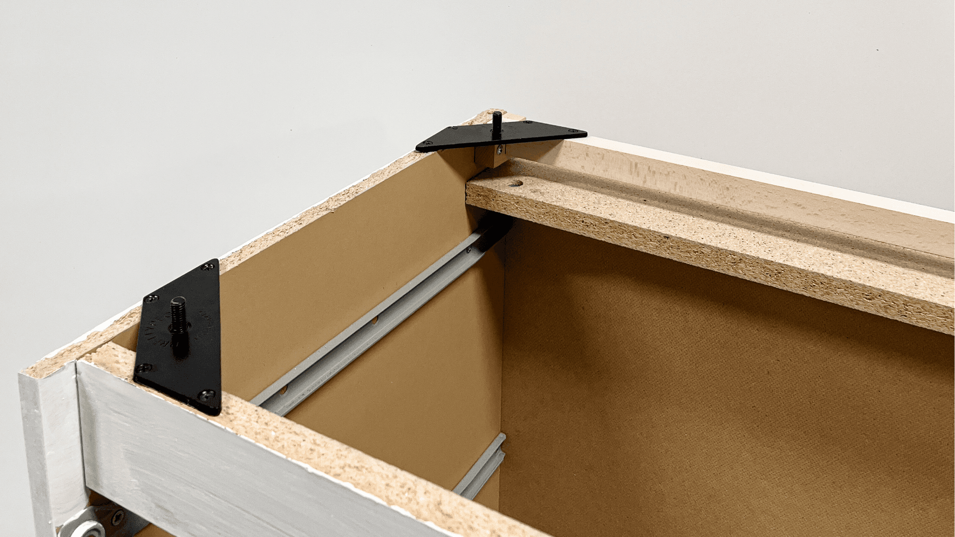 Unterseite einer IKEA MALM Kommode mit Montageplatten und Bracket zur Befestigung von Möbelfüßen