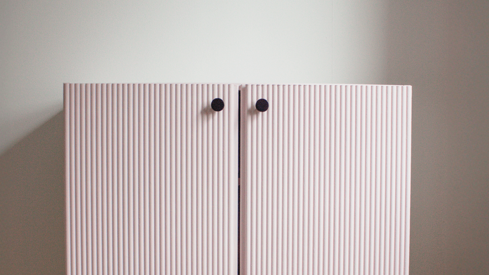 Portes d’armoire IKEA IVAR roses cannelées avec boutons noirs montrant le relooking final du meuble IVAR avec panneaux décoratifs