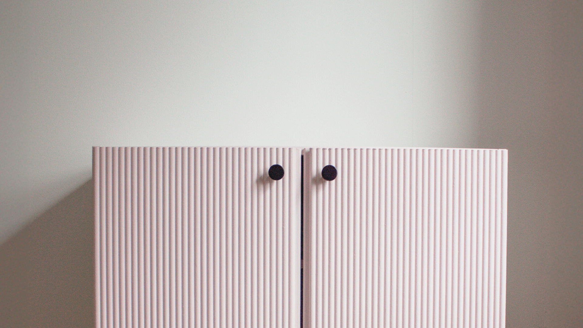 Fluted pink IKEA IVAR cabinet doors with black knobs showing the finished IVAR cabinet makeover using decorative panels