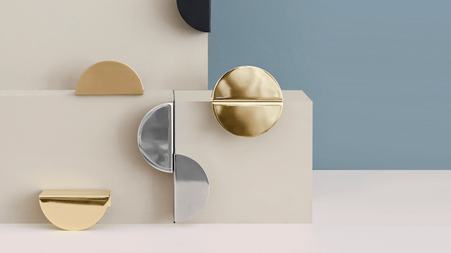Prettypegs half-moon cabinet handles in brass, silver, and black finishes displayed on beige blocks.