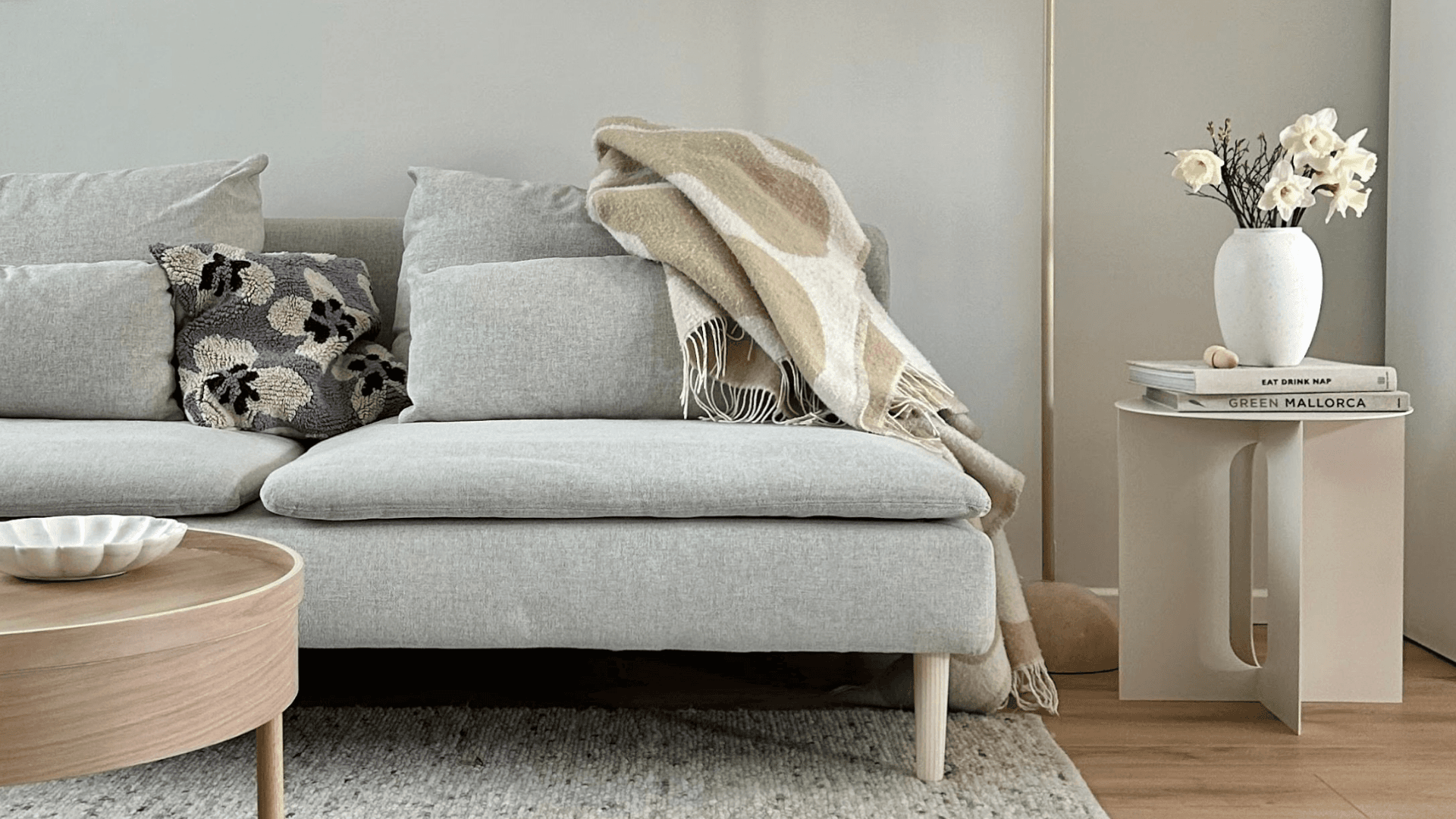 Salon scandinave avec canapé gris, table ronde en bois et pieds Prettypegs pour un look minimaliste