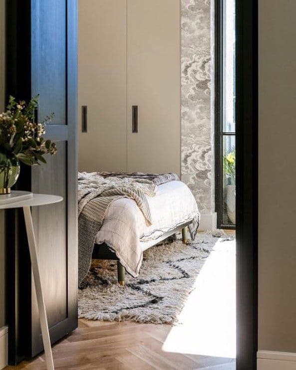 lit IKEA avec pieds en métal dans une chambre élégante avec textiles et tapis